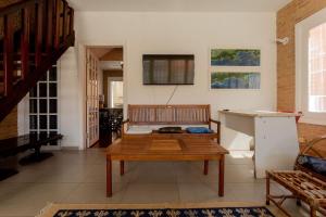 a living room with a bench and a table at Casa c/ churrasqueira próximo à praia em Ubatuba in Ubatuba