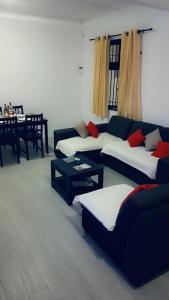 ein Wohnzimmer mit zwei Sofas und einem Tisch in der Unterkunft Residence Frangipani in Pereybere