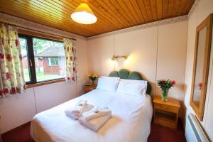 a bedroom with a bed with two towels on it at Heron chalet in Crianlarich