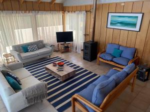 uma sala de estar com dois sofás e uma mesa em Casa en Pingueral em Dichato