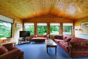 a living room with couches and a flat screen tv at The Buzzard in Crianlarich