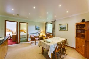 a living room with a table and a bedroom at The Buzzard in Crianlarich