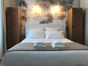 - une chambre avec un lit et 2 serviettes dans l'établissement Maison Caju - La Rochelle, à La Rochelle