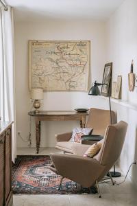 een kamer met 2 stoelen en een tafel en een kaart aan de muur bij Les Suites de Catherine, la 35 in Nancy