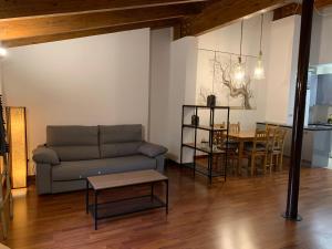 sala de estar con sofá y mesa en Atico Jaca Centro, en Jaca