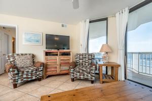 a living room with two chairs and a flat screen tv at 220 Charleston Oceanfront Villas Dolphin View in Folly Beach