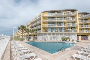 a hotel with a swimming pool and chairs and a building at 220 Charleston Oceanfront Villas Dolphin View in Folly Beach