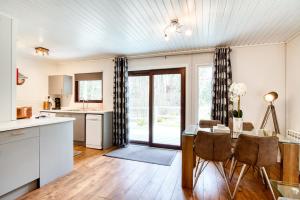 a kitchen and dining room with a table and chairs at Otter chalet in Crianlarich