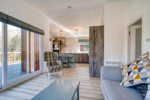 a living room with a couch and a table at Gamekeeper chalet in Crianlarich