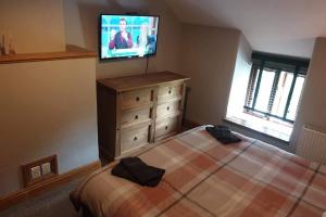 1 dormitorio con 1 cama y TV de pantalla plana en Cosy Minffordd Let - Llanuwchllyn near, Bala LL23, en Bala