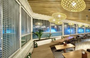a restaurant with tables and chairs and windows at Tanoa Plaza Hotel in Suva