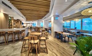 a restaurant with wooden tables and chairs and windows at Tanoa Plaza Hotel in Suva