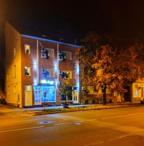a building with blue lights on a street at night at Rooms Villa Luigi in Pančevo