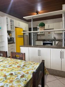 a kitchen with a table and a yellow refrigerator at Pousada Temporada in Arraial do Cabo