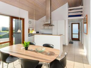 Thorsminde的住宿－Three-Bedroom Holiday home in Ulfborg 27，厨房以及带木桌和椅子的用餐室。