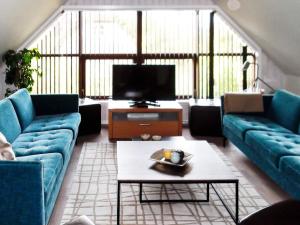 a living room with two blue couches and a tv at 8 person holiday home in N rre Nebel in Nørre Nebel
