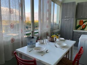 una mesa blanca con 2 sillas y una ventana en Baia Verde Apartment, en Baia Verde