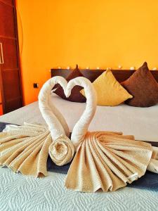 dwa łabędzie tworzące kształt serca na łóżku w obiekcie Wonderful Sea Views w mieście Costa Del Silencio