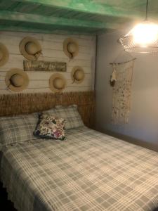 ein Schlafzimmer mit einem Bett mit einer Decke und Hüten an der Wand in der Unterkunft Independent Studio in Little Havana - 4V in Miami
