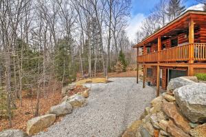 a log cabin in the woods with a stone wall at Rustic North Conway Cabin Less Than 3 Mi to Cranmore Mtn! in North Conway