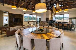 ein Wohnzimmer mit einem großen Holztisch und Stühlen in der Unterkunft CasaGrande no topo dos Canions. in Bom Jardim da Serra