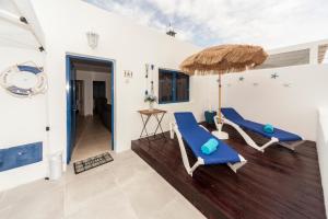 a patio with two blue chairs and an umbrella at Luxury Suite Sea Front III in Playa Honda