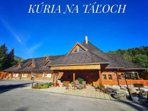 un chalet en rondins avec un grand toit dans l'établissement Penzión & apartmány Kúria na Táľoch, Tále - Chopok JUH, à Tale