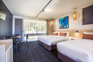 um quarto de hotel com duas camas e uma mesa em Nightcap at Gateway Hotel em Corio