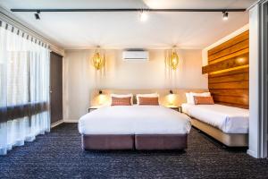 a hotel room with two beds and two lamps at Nightcap at Gateway Hotel in Corio