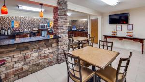 a bar with tables and chairs in a restaurant at Best Western Inn & Suites of Macon in Macon
