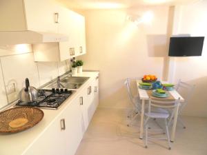 a kitchen with a sink and a table with chairs at Twins Apartments in Bari