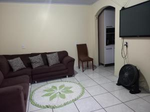 uma sala de estar com um sofá e uma televisão de ecrã plano em Sobrado 02 quartos próx. Hotel Recanto Cataratas em Foz do Iguaçu