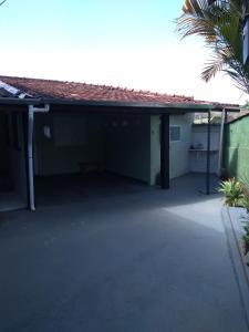 an empty garage with a building and a palm tree at Casa e Suíte Recanto Zen in Santo Antônio do Pinhal