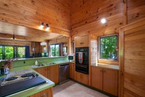 a kitchen with wooden cabinets and a stove top oven at Lake Terrace Lockwood in Taupo