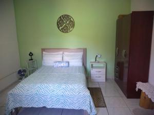 a bedroom with a bed with a blue and white comforter at Casa e Suíte Recanto Zen in Santo Antônio do Pinhal