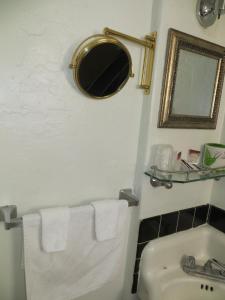 
a bathroom with a sink, toilet and mirror at El Trovatore Motel in Kingman
