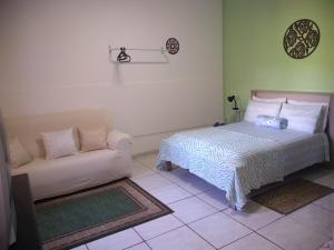 1 dormitorio con 1 cama y 1 sofá en Casa e suíte Recanto Zen, en Santo Antônio do Pinhal