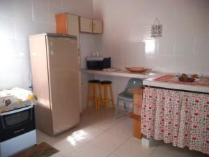cocina con nevera, mesa y sillas en Casa e suíte Recanto Zen, en Santo Antônio do Pinhal