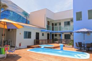 a patio with a swimming pool and a house at Hotel e Pousada Boulevard de Itapoa in Itapoa
