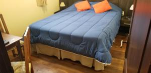 a blue bed with two orange pillows on it at Hotel Trinidad in Trinidad