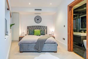 een slaapkamer met een bed en een klok aan de muur bij ARCORE Premium Rental Shaftesbury Avenue in Londen