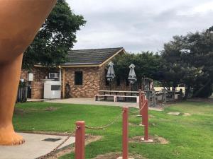 a house with a bench in front of a yard at The Golden Dog Hotel in Nana Glen