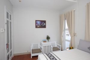 a white bedroom with a bed and a window at Nha Trang Pearl Hotel in Nha Trang