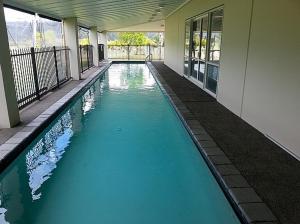 a swimming pool in the middle of a building at Putt it at Pauanui - Pauanui Holiday Home in Pauanui