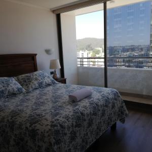 - une chambre avec un lit et une grande fenêtre dans l'établissement Departamento Freire 1905, à Concepción