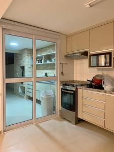 a kitchen with a large sliding glass door at Enseada Arvoredos in Guarujá