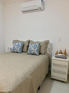 um quarto com uma cama e ar condicionado em Enseada Arvoredos no Guarujá