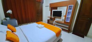 une chambre d'hôtel avec un lit et une télévision dans l'établissement Residence Duksina 2 By SHM, à Yogyakarta