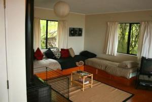 a living room with a couch and a table at Nestled Atop the Lane - Pukawa Bay Holiday Home in Kuratau