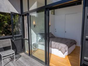 a bedroom with a bed and sliding glass doors at Bauhaus - Kaiteriteri Holiday Home in Kaiteriteri